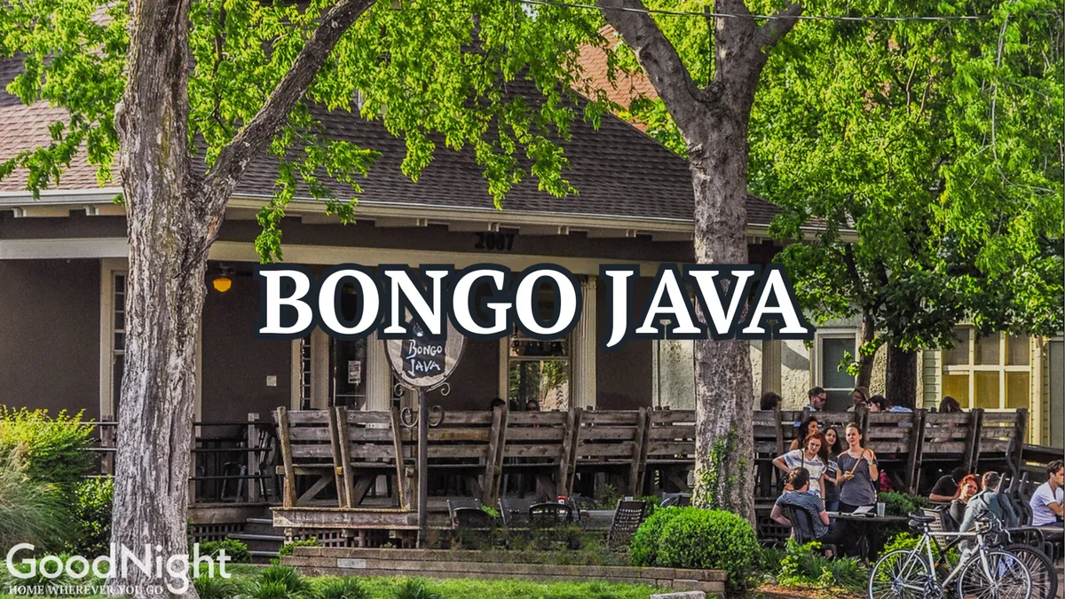 An exterior shot of Bongo Java, a local coffeehouse with an inviting outdoor seating area and people socializing and working. The scene is lively yet relaxed, perfect for business travelers needing a change of pace to work remotely or network informally.