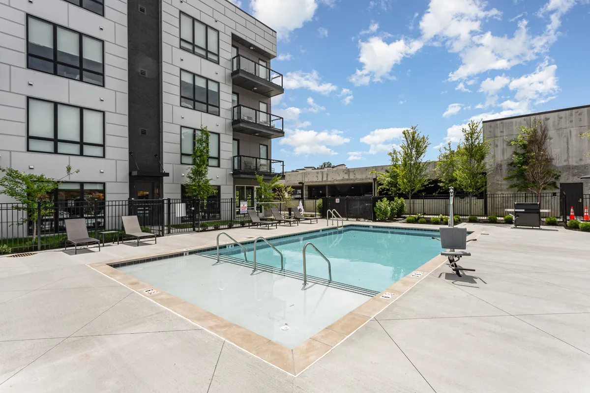 This image presents the building’s resort-style pool area, complete with modern seating and balconies overlooking the space. The pool suggests a vibrant social hub where groups can relax or recharge after a day in the city.