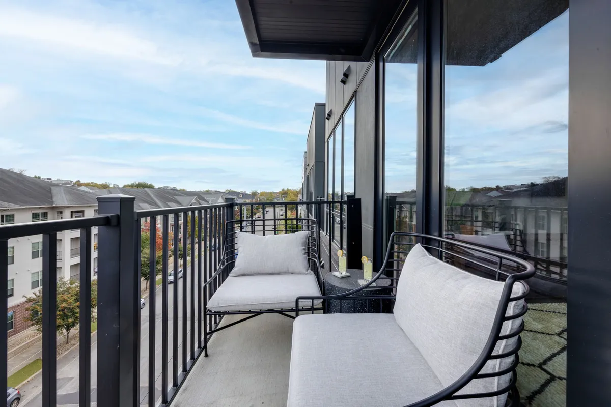 A private balcony with comfortable seating and a decorative table overlooking city views. The balcony radiates tranquility, perfect for enjoying a morning coffee or evening drinks while soaking in the urban environment.